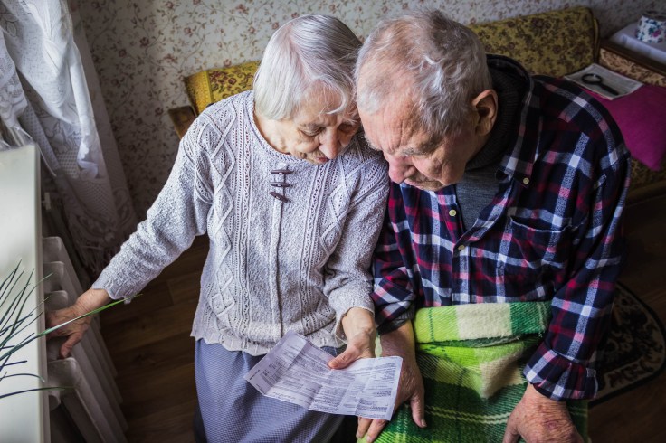 Woman holding cash in front of heating radiator. Payment for heating in winter. Selective focus.